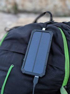 portable solar phone charger hanging from a backpack